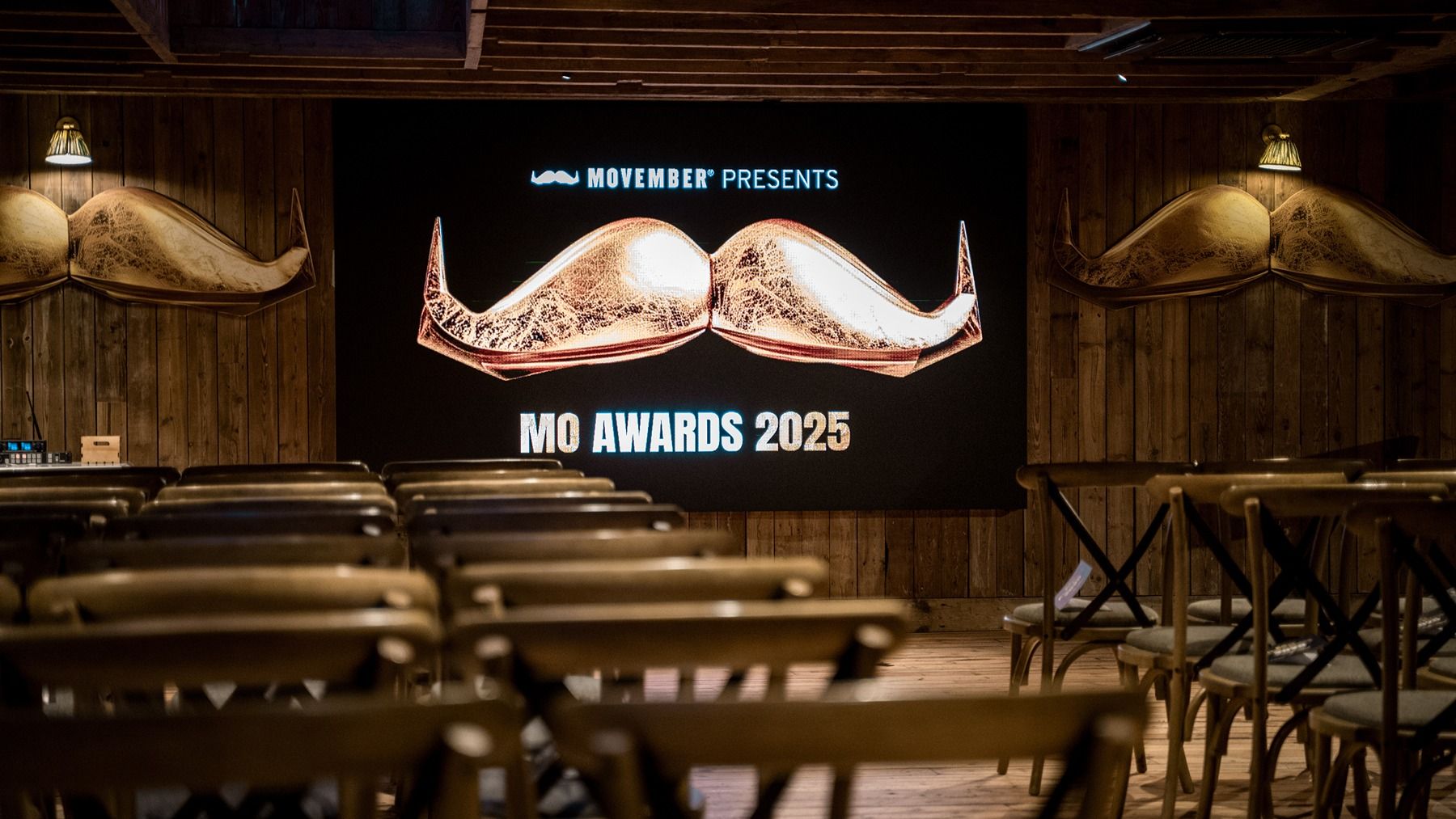 Photo of a reception venue with a Movember sign on the stage. 