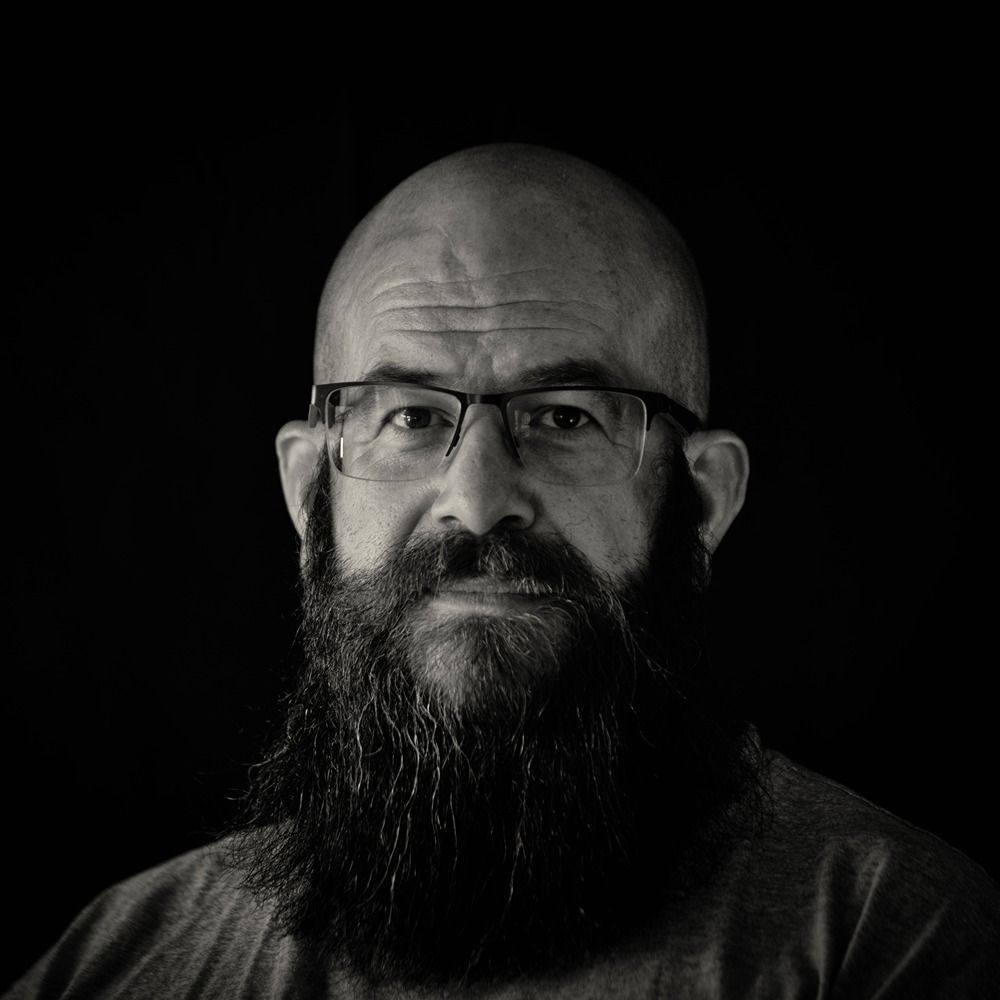 Black and white portrait photo of man sporting a large, dark beard.