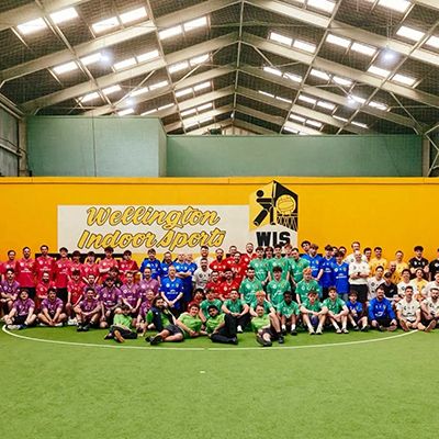 Photo showing sports teams in uniforms of different colours posing to camera.