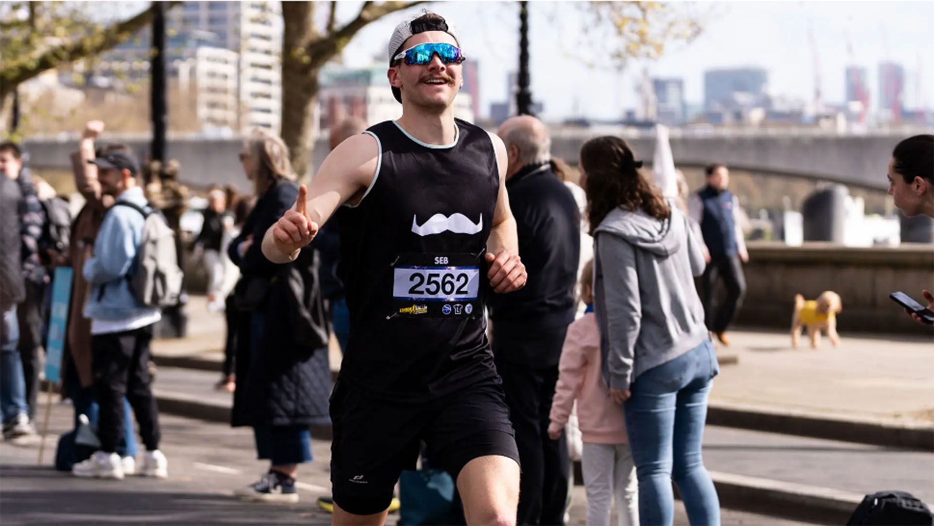 Photo of Movember supporter, wearing Movember-branded running gear, running triumphantly to camera.