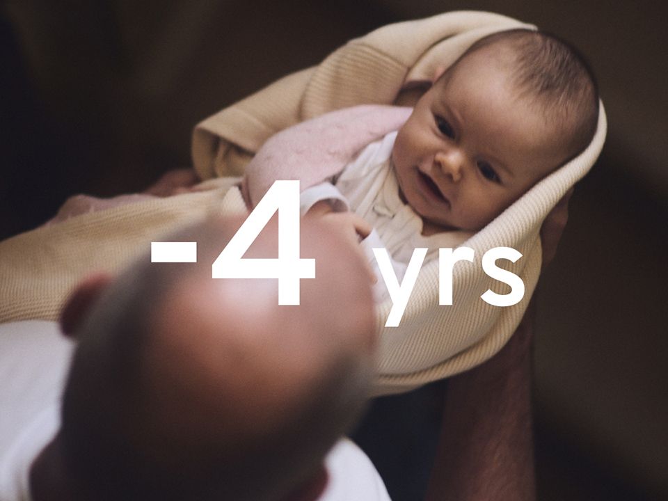 Dramatic image showing an infant, lovingly held by an elderly male relative. The figure "-4 years" is superimposed in large white text.