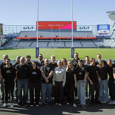 Photo of Movember representatives at a sports stadium.