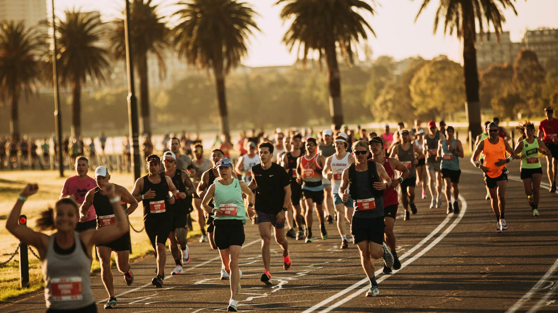 Runners along a scenic palm tree lined road