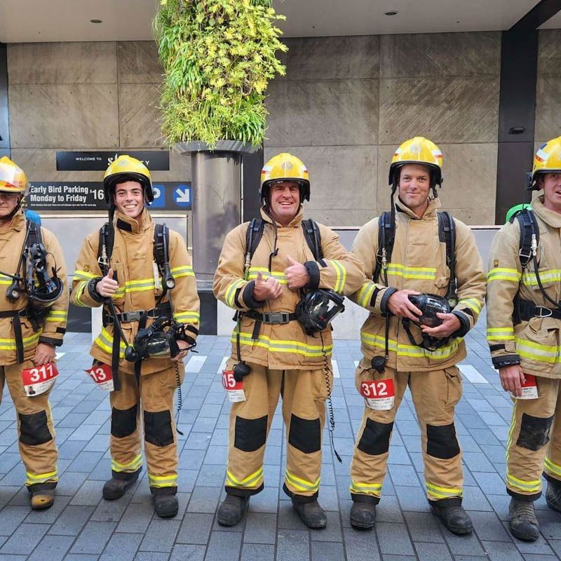 Photo of firefighters in full gear, smiling to camera.