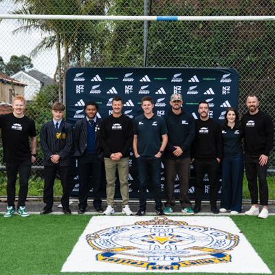 Photo of representatives from Movember and Rugby NZ in front of a media banner.