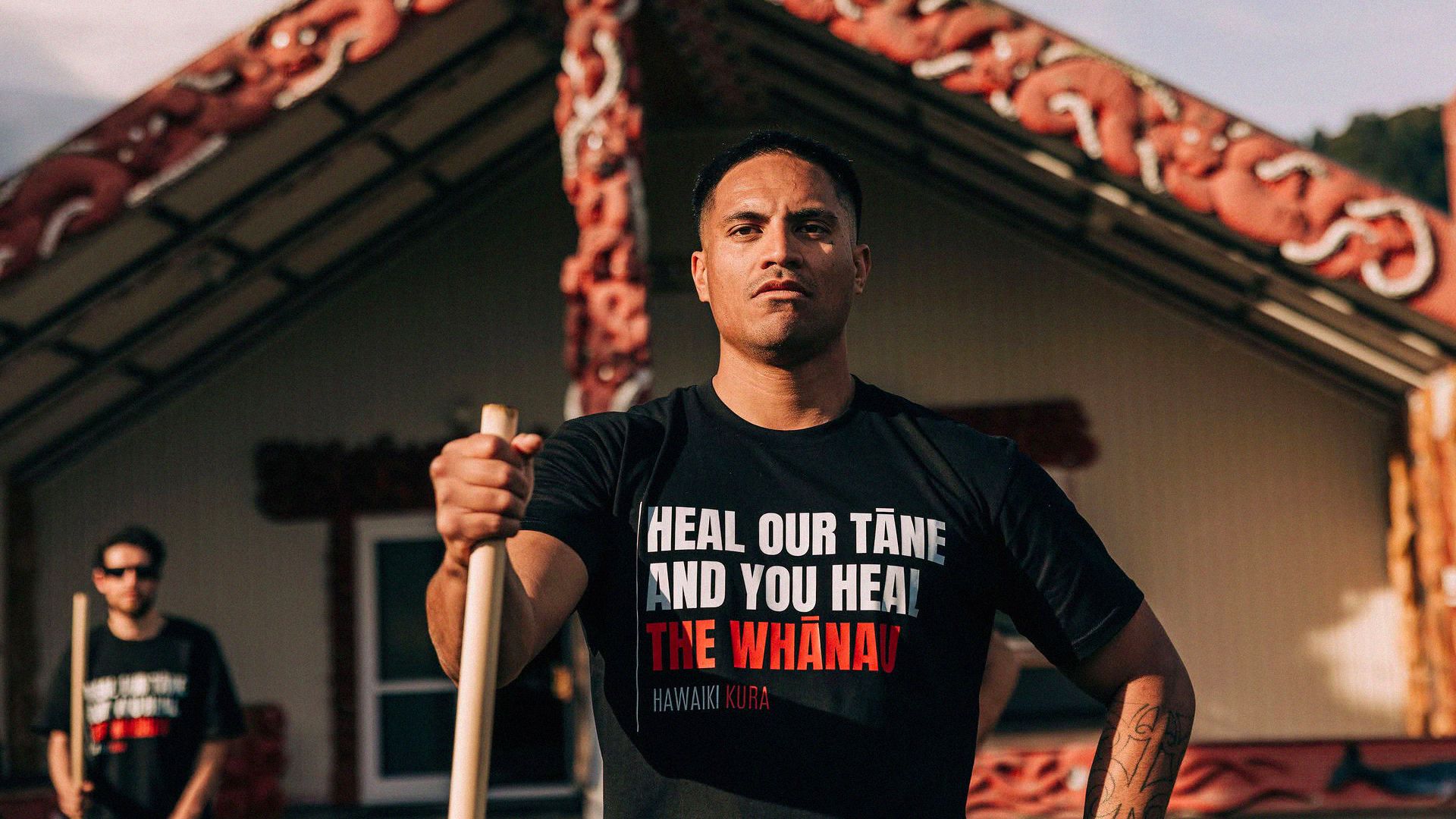 Man stands outside traditional māori meeting place