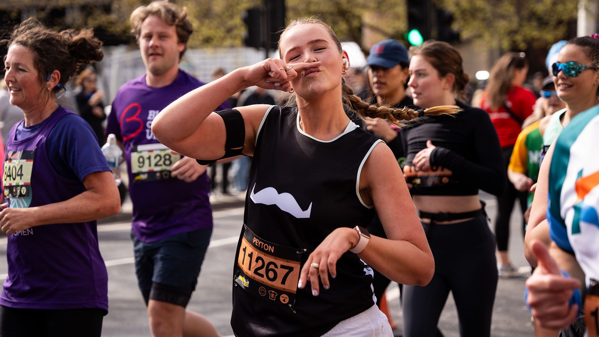 Smiling marathon runner in Movember-branded attire looking to camera.