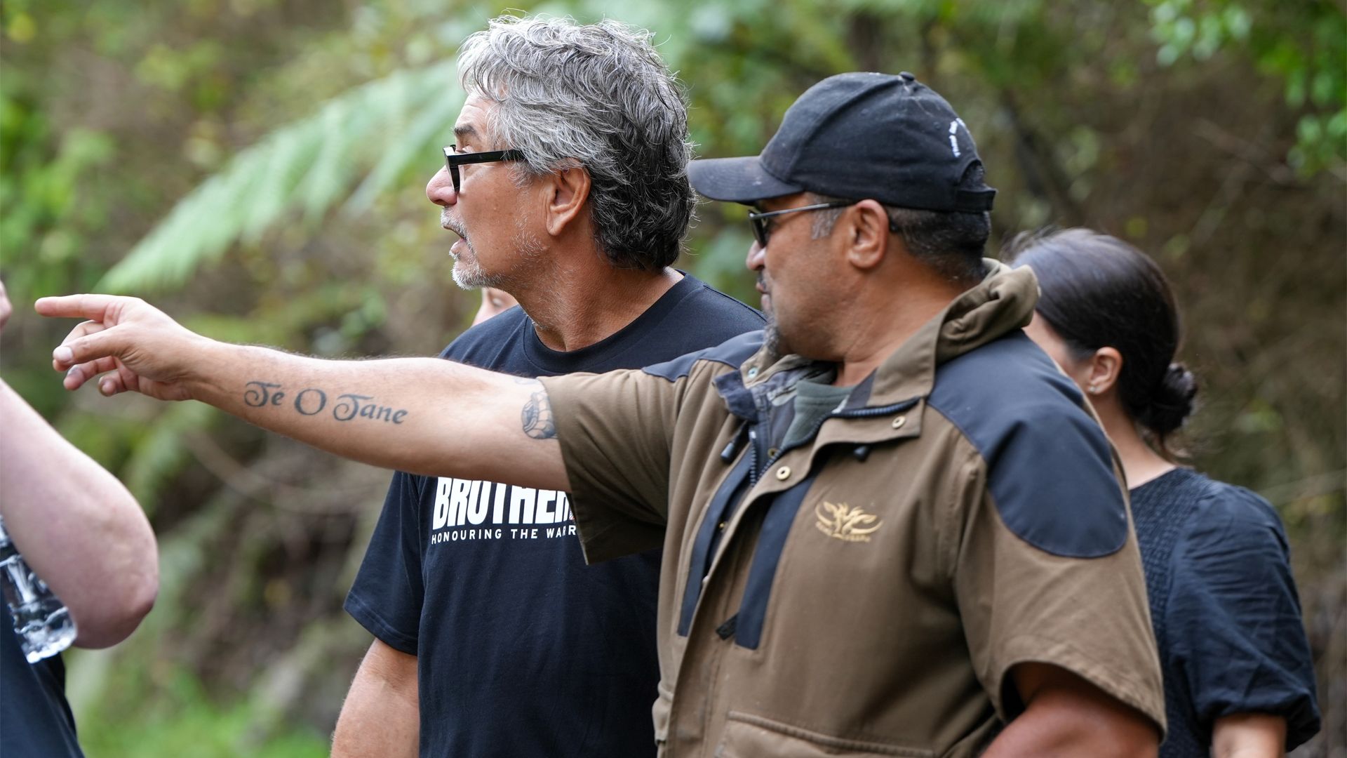 Two men outside identifying native plants to use for traditional medicine