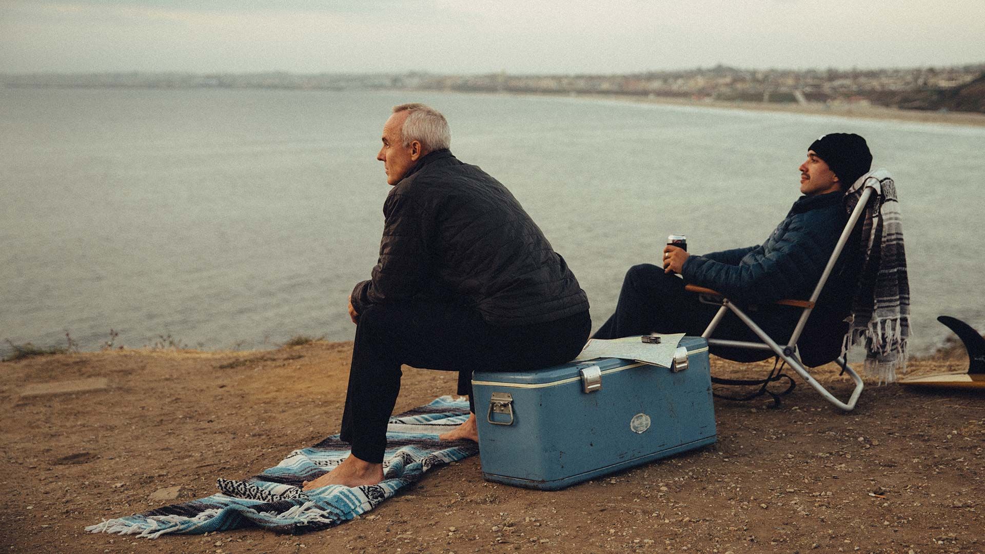 A father and son sitting down overlooking the beach