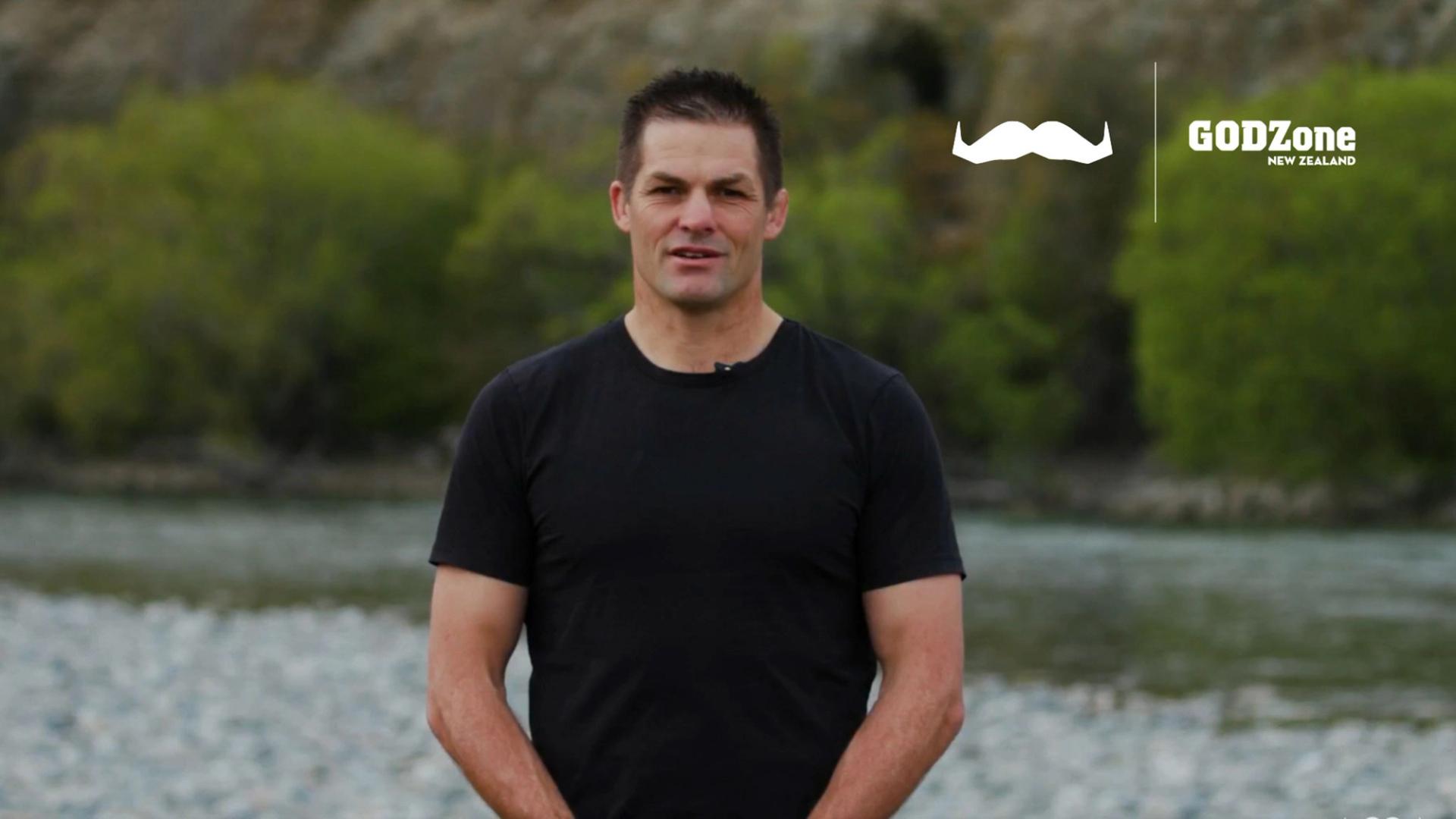 Photo of a man in a black shirt, looking to camera.