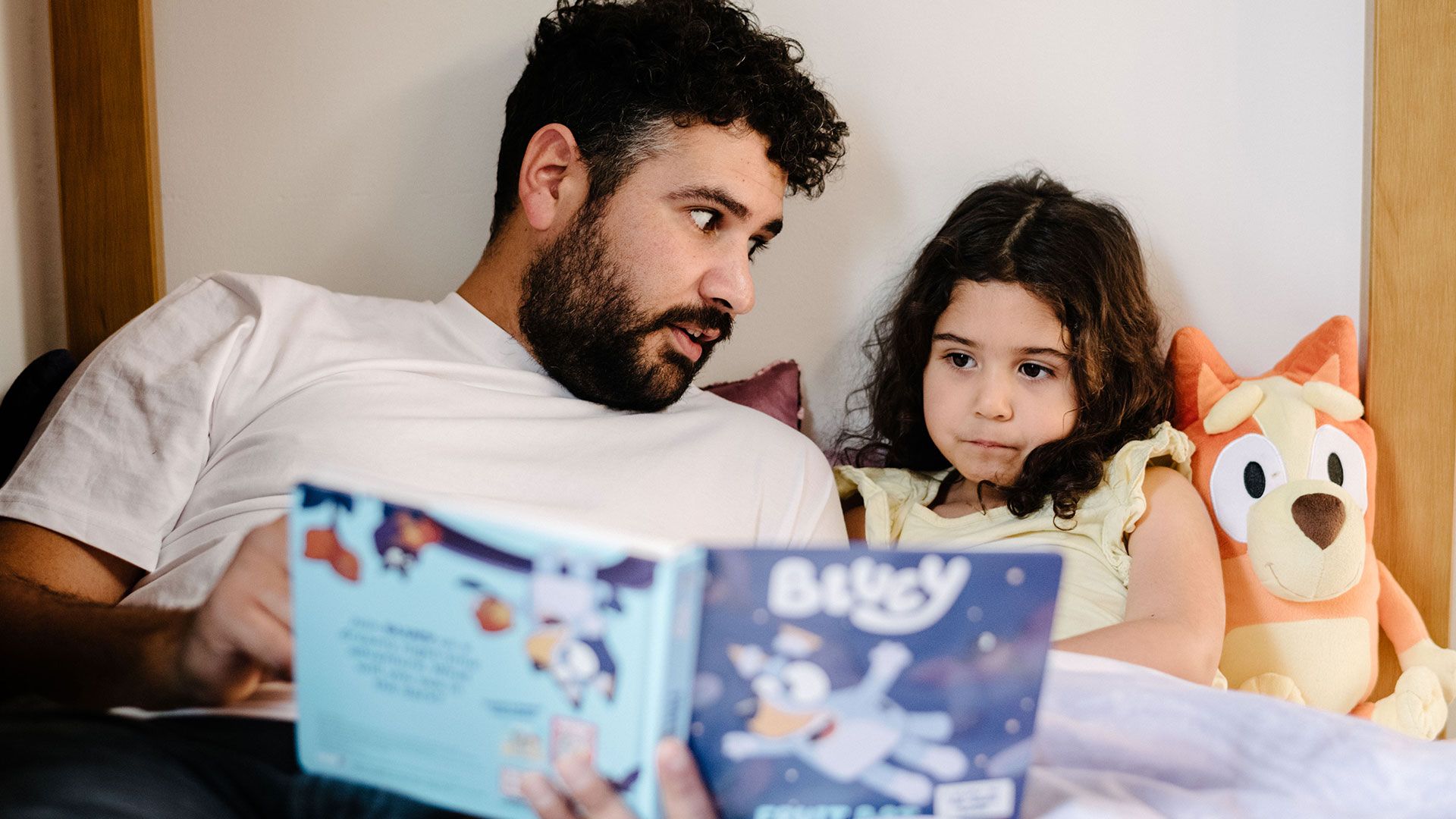 A father reading his daughter a bed time story